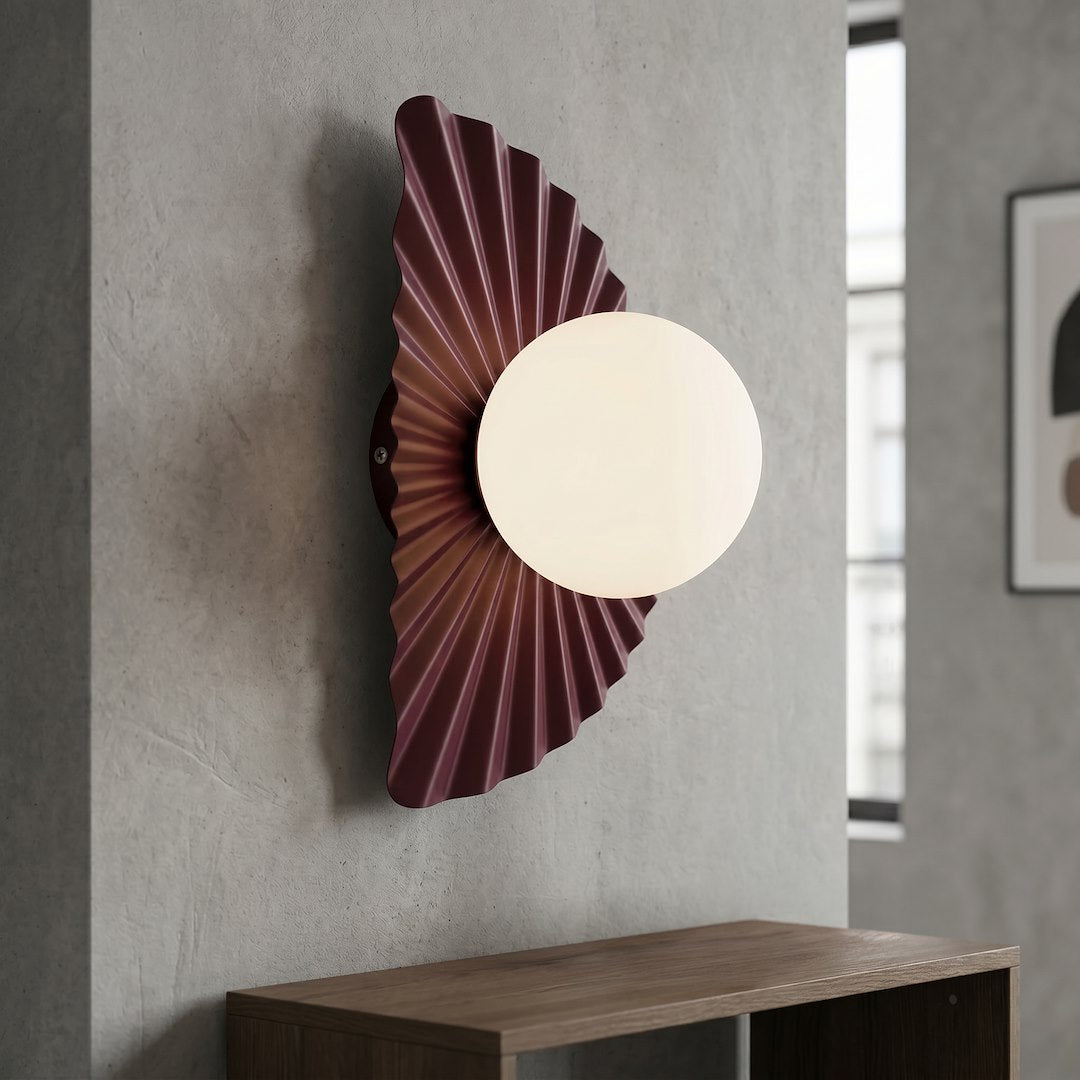 Applique bordeaux allumée sur un mur en béton, au-dessus d'un meuble en bois.