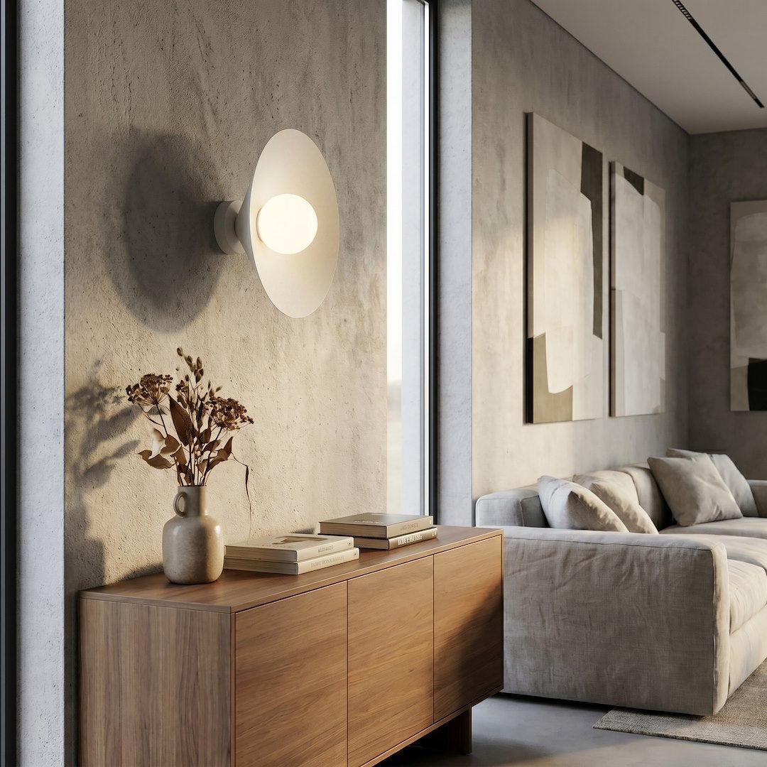 Mise en ambiance dans un salon, applique allumée au-dessus d'un meuble en bois
