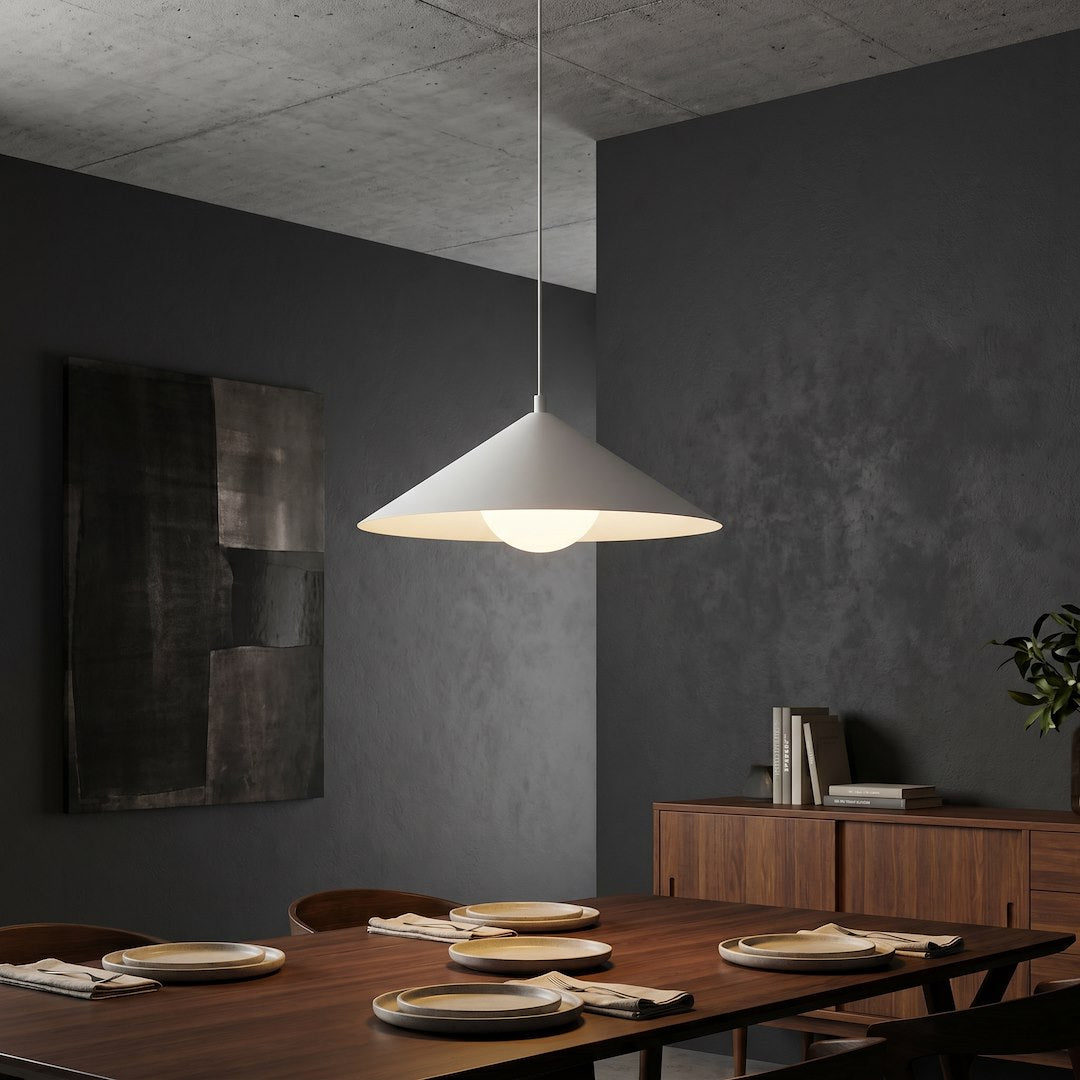 Ambiance salle à manger sombre, suspension blanche allumée au-dessus de la table dressée