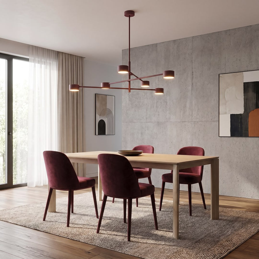 Salle à manger avec plafonnier bordeaux au-dessus table en bois et chaises velours