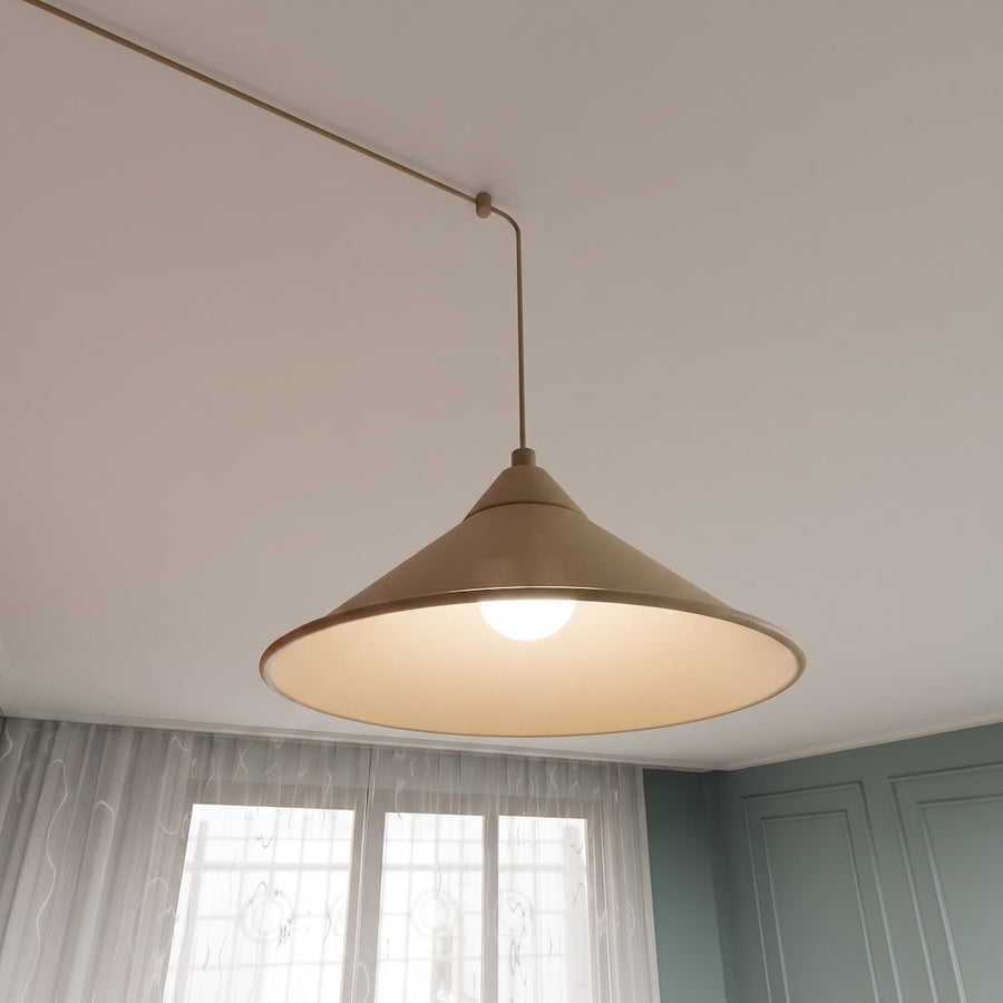 Gros plan d'un abat-jour conique beige allumé, vu de dessous près du plafond.