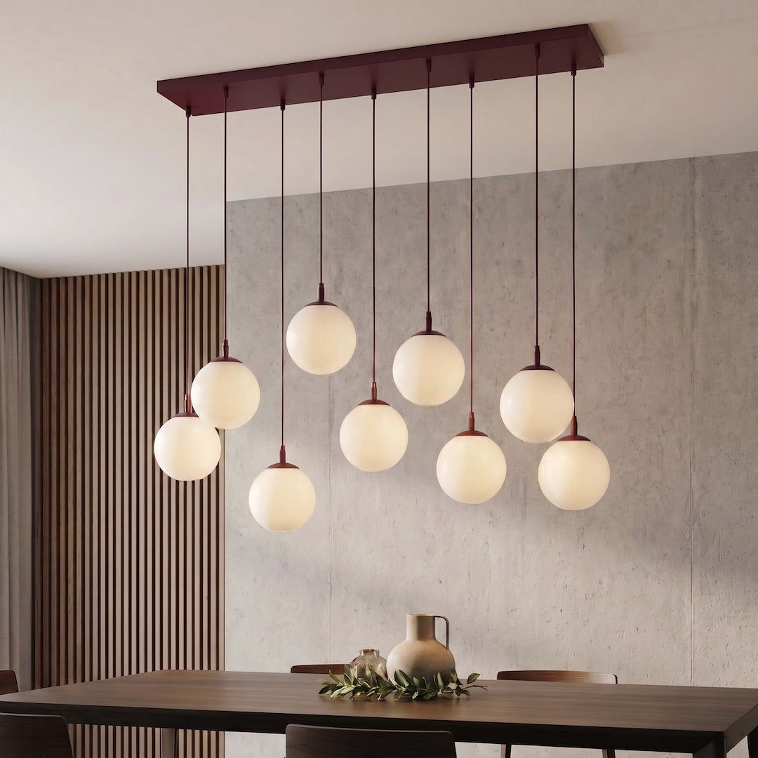 Luminaire installé au-dessus d'une table en bois, mur béton et claustra vertical en bois