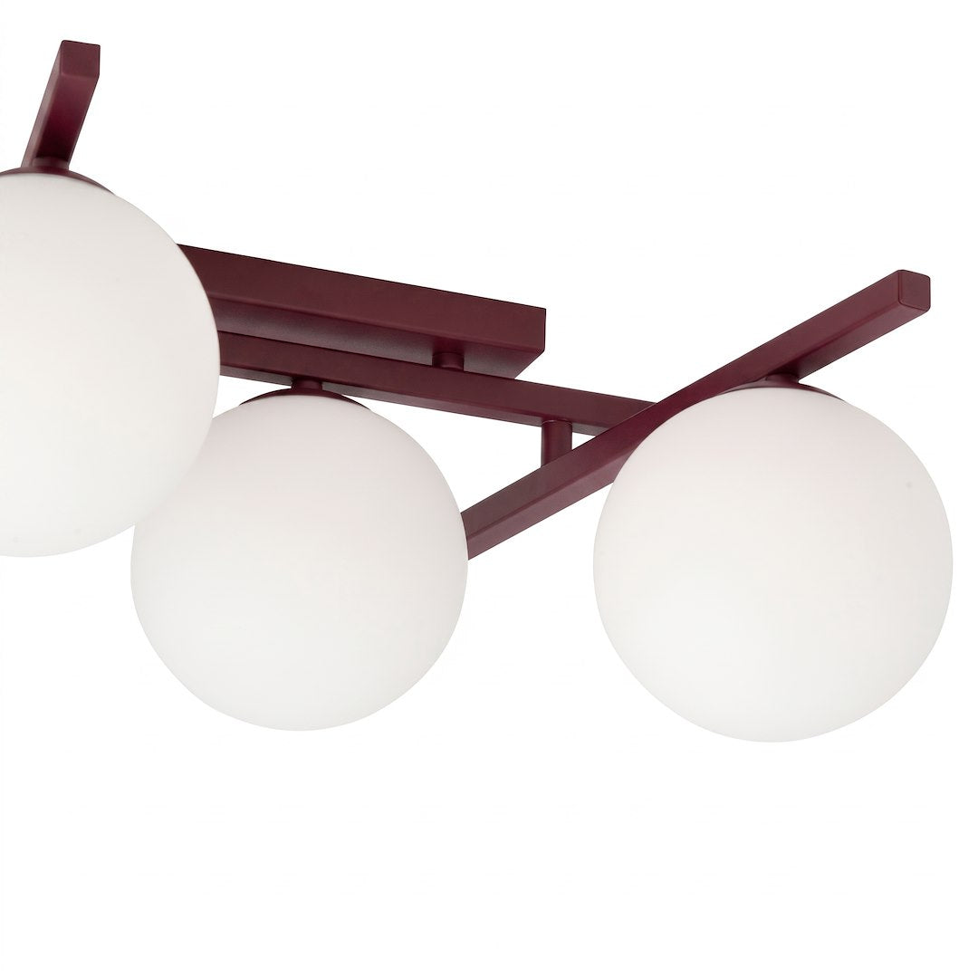 Détail rapproché des globes en verre blanc et de la structure bordeaux.