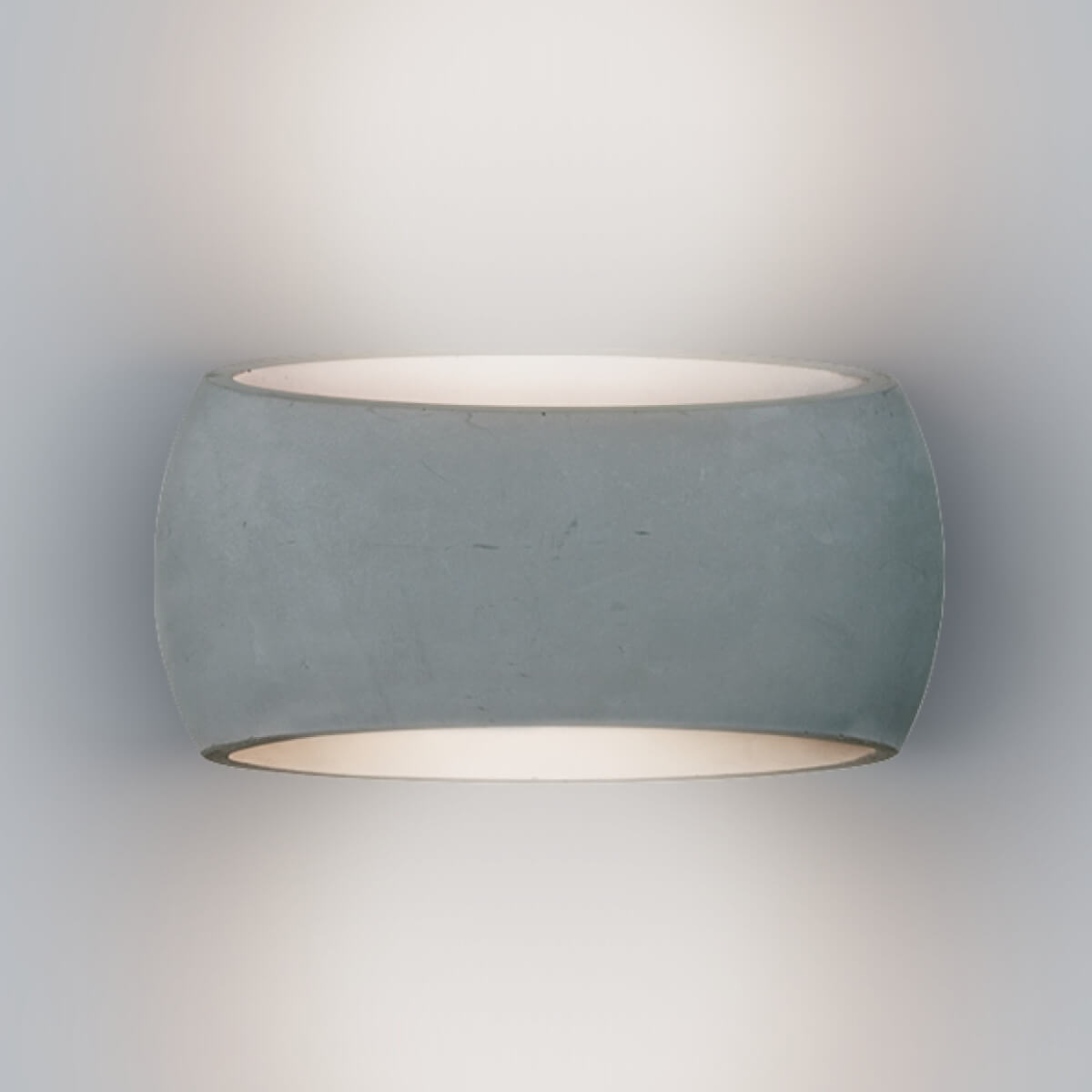 Vue rapprochée du cylindre en béton gris avec ses ouvertures lumineuses