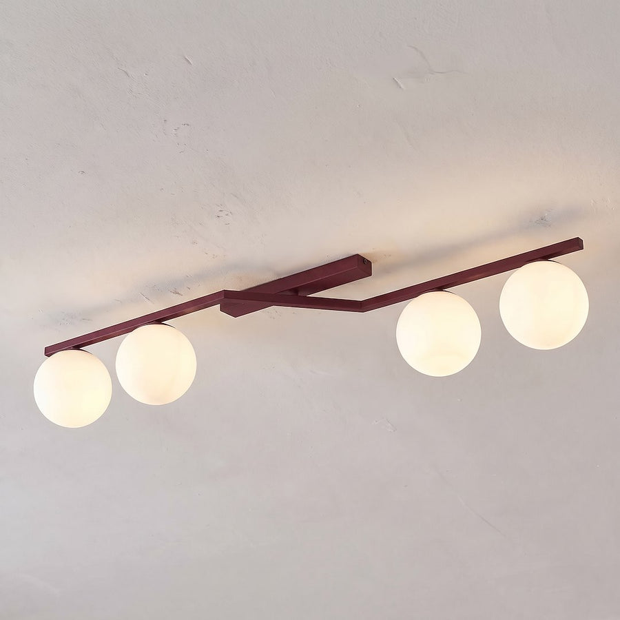 Vue de dessous du luminaire fixé au plafond, quatre globes allumés alignés