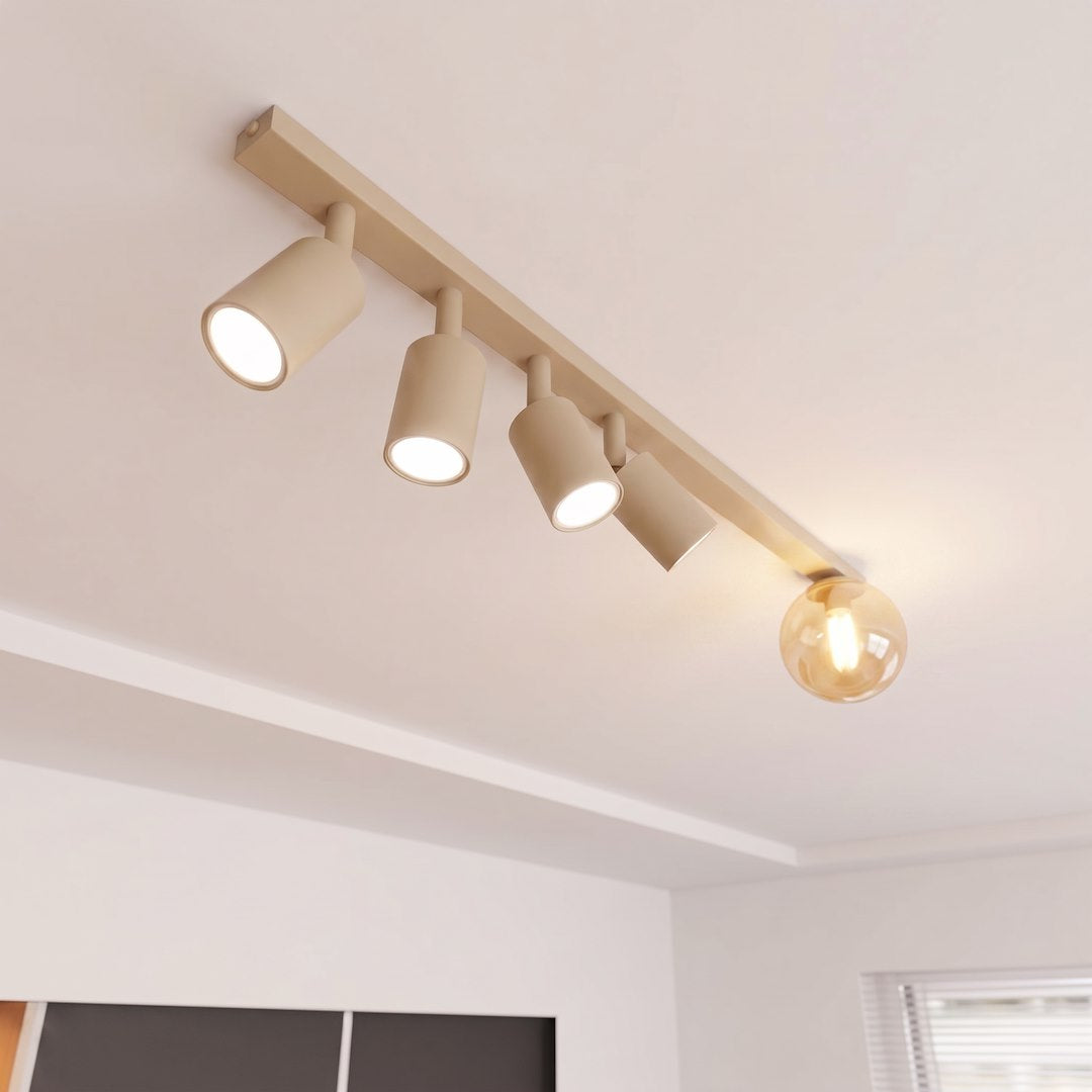 Gros plan en contre-plongée montrant les quatre spots beiges et la sphère ambrée allumée.