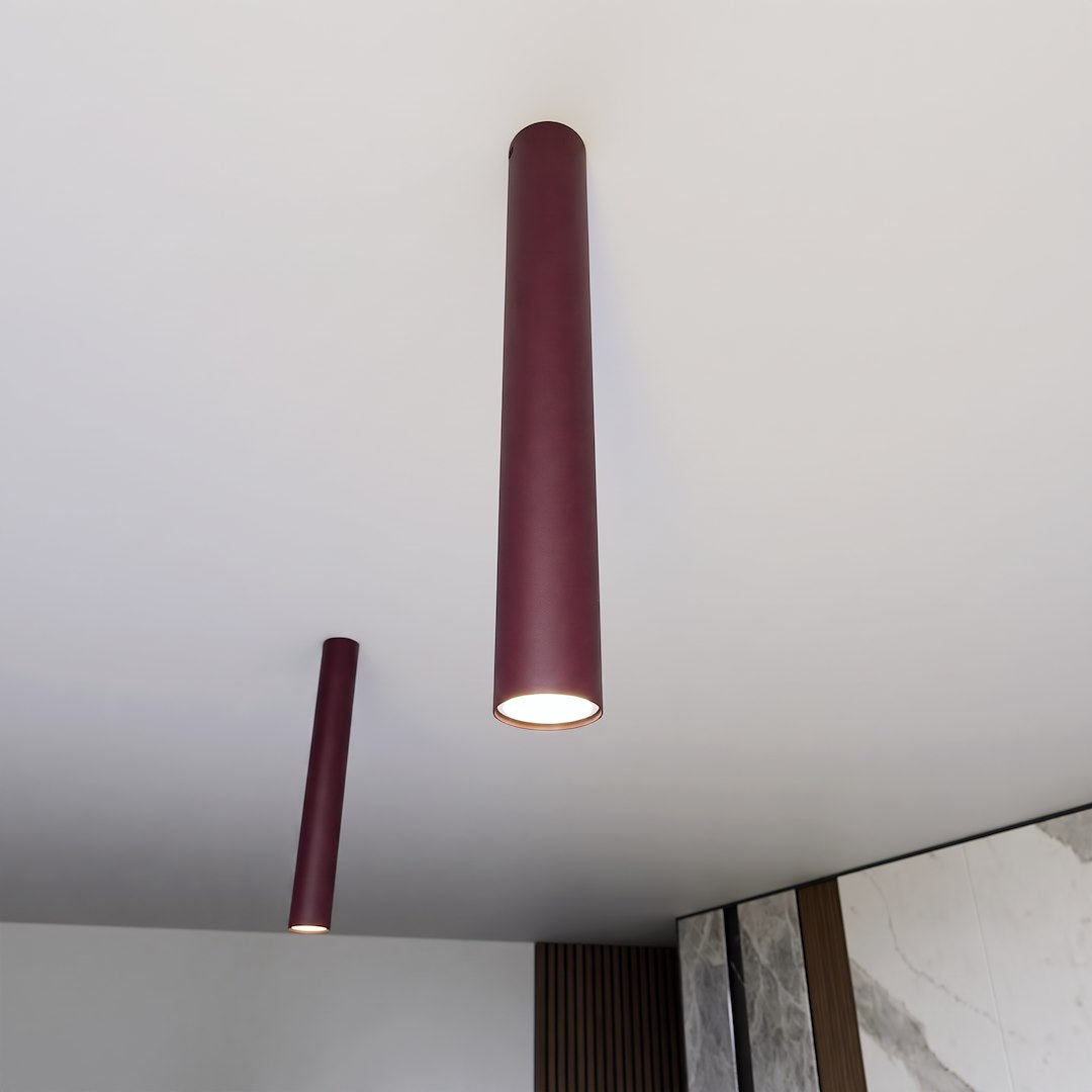 Deux tubes fins fixés au plafond blanc, éclairage chaud allumé vers le sol