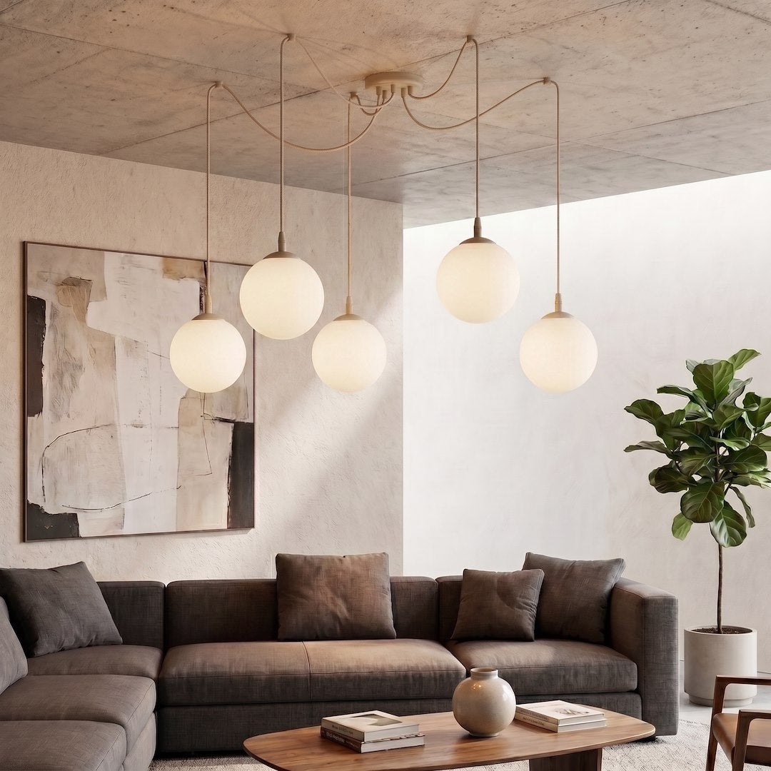 Mise en ambiance salon, suspension allumée au-dessus d'un canapé gris et table basse