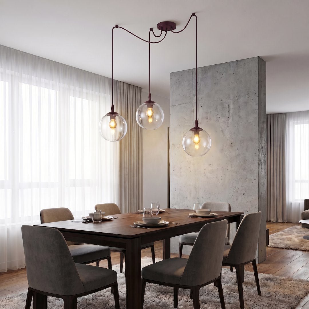 Mise en ambiance au-dessus d'une table à manger, trois globes allumés