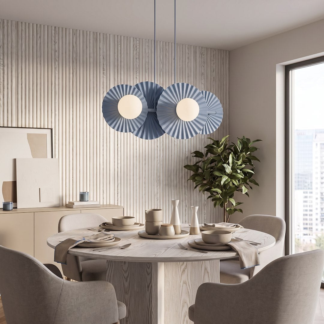 Suspension bleue installée au-dessus d'une table ronde dans une salle à manger.