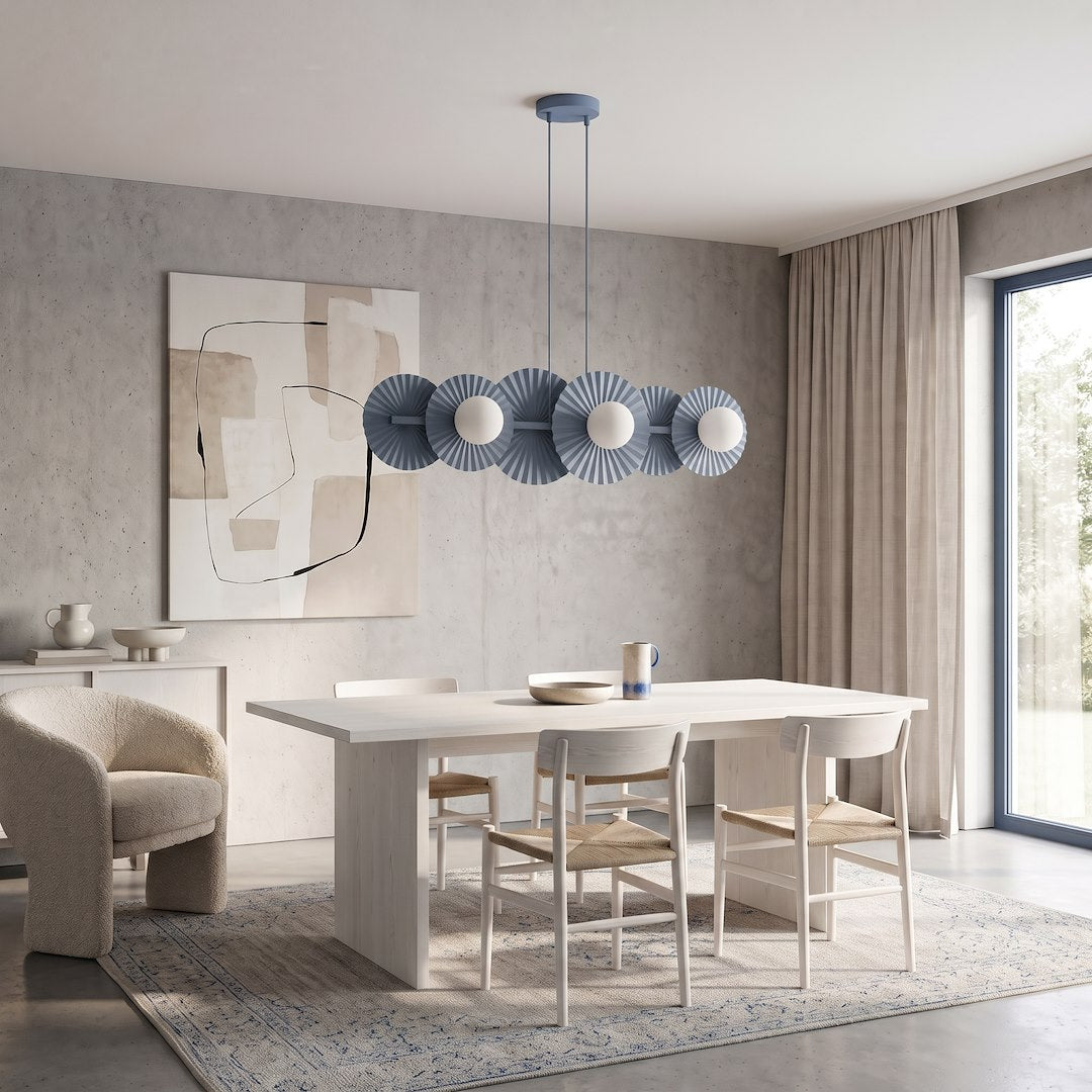 Suspension bleue suspendue au-dessus d'une table dans une salle à manger lumineuse