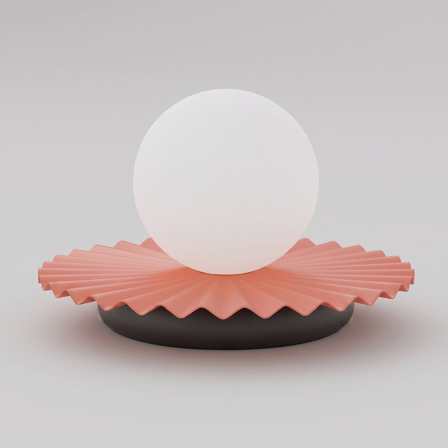 Lampe à poser de face, sphère blanche en verre sur socle corail plissé