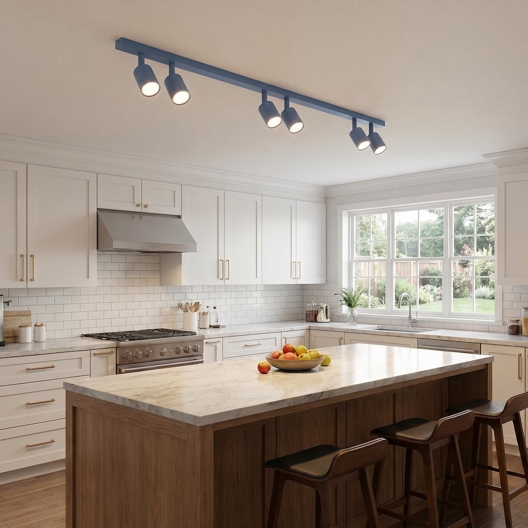 Ambiance cuisine blanche avec îlot central, plafonnier bleu fixé au plafond