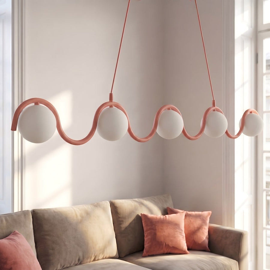 Luminaire suspendu ondulé rose au-dessus d'un canapé beige dans un salon
