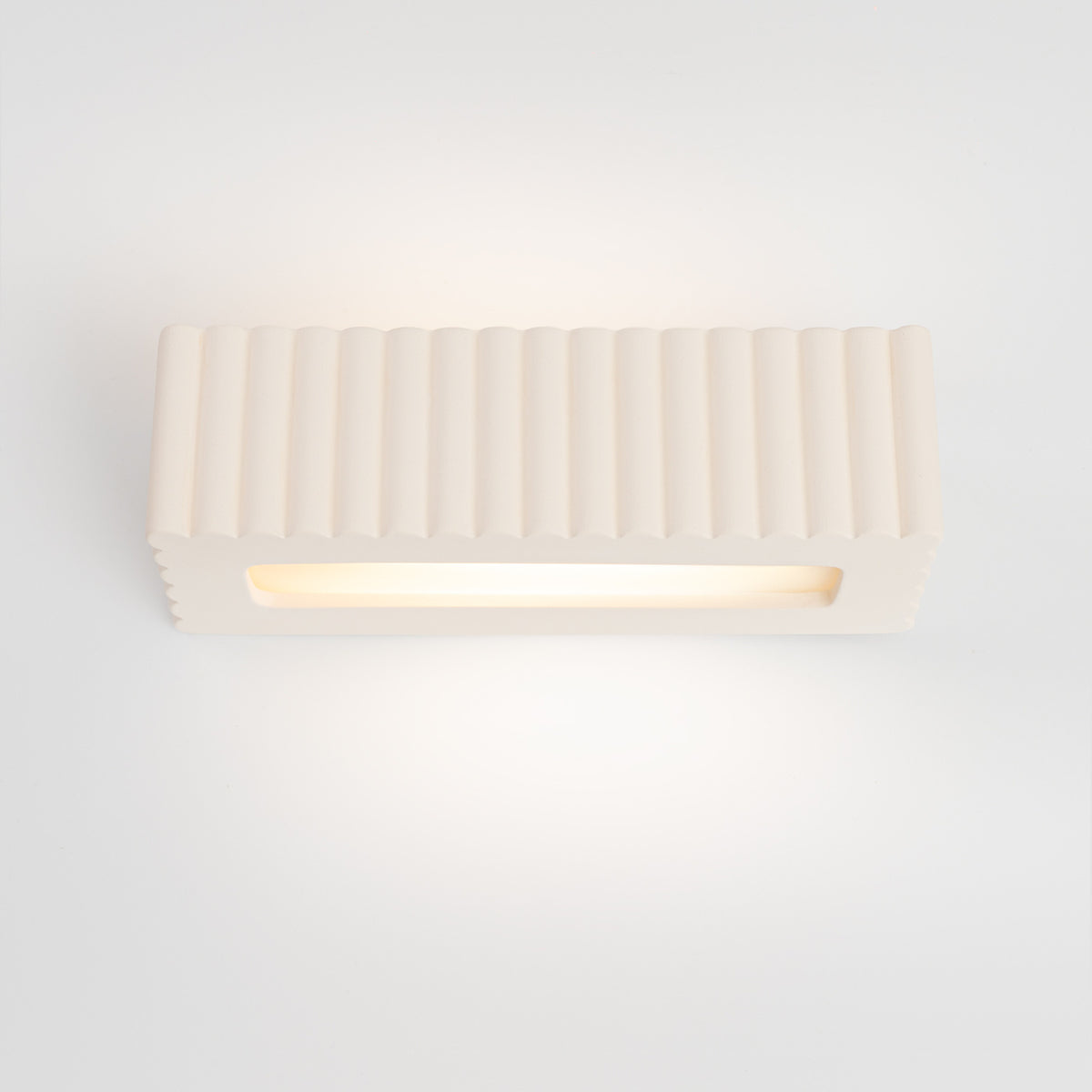 Vue frontale à plat, bandeau LED lumineux sous la coque céramique cannelée.
