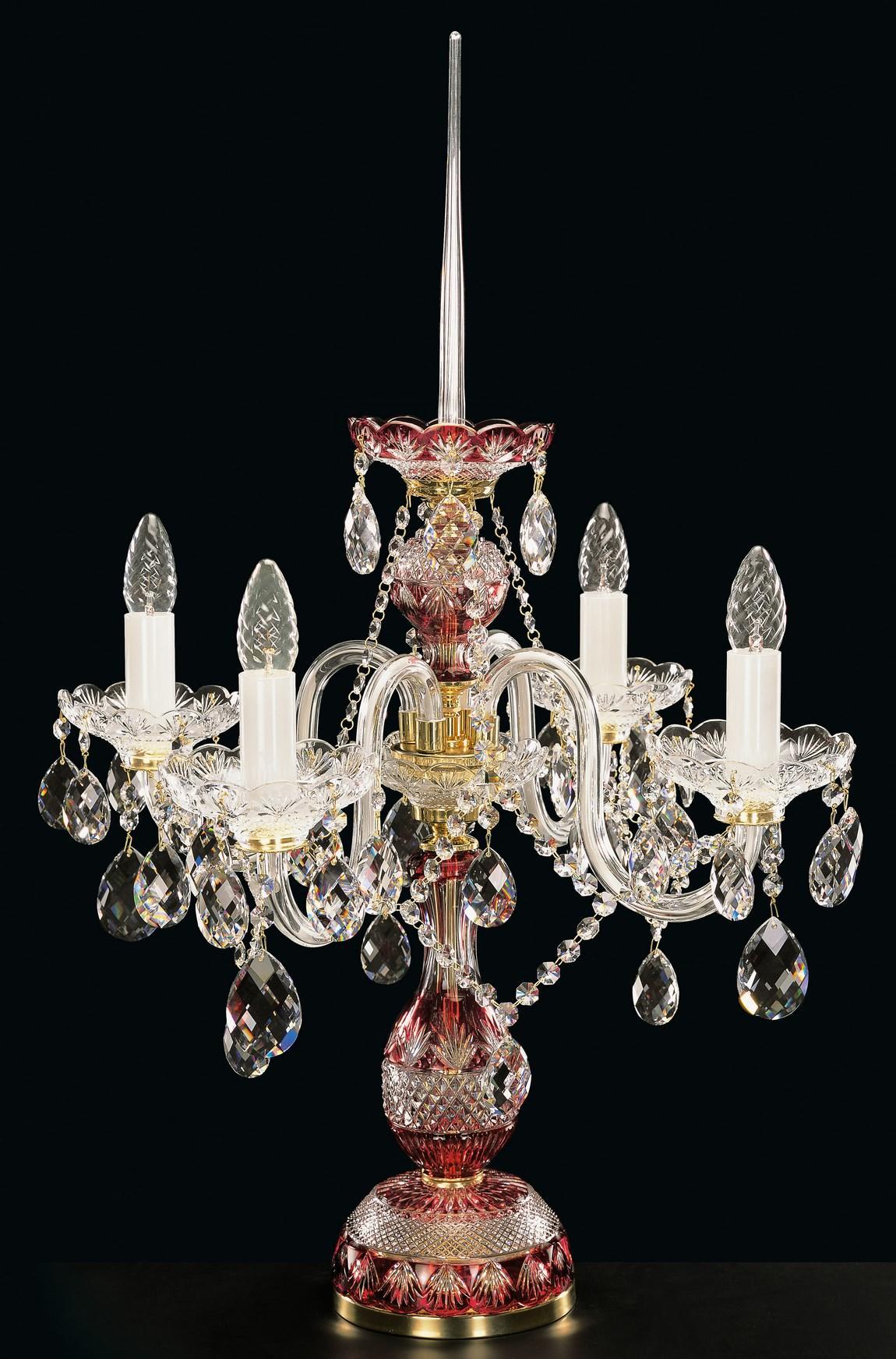 Lampe à poser en cristal teinté rouge, cinq bras, pendeloques, vue de face sur fond noir.