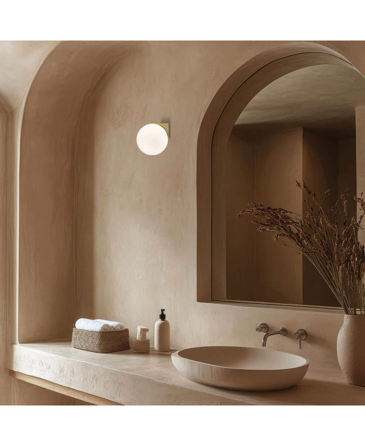 Détail de la sphère opaline allumée dans un décor de salle de bain aux tons sable.