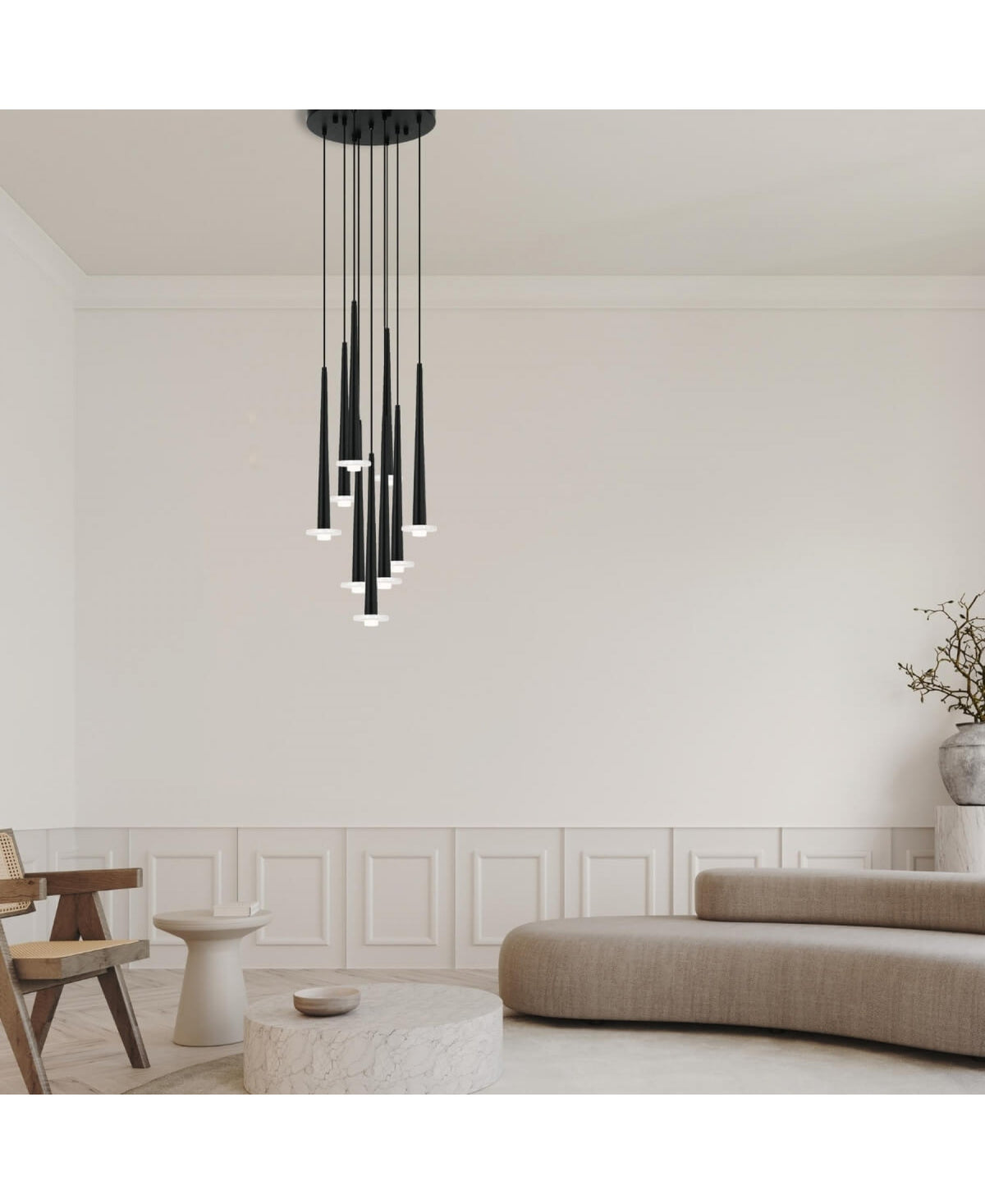 Ambiance salon clair, suspension allumée au-dessus du coin assise et moulures.