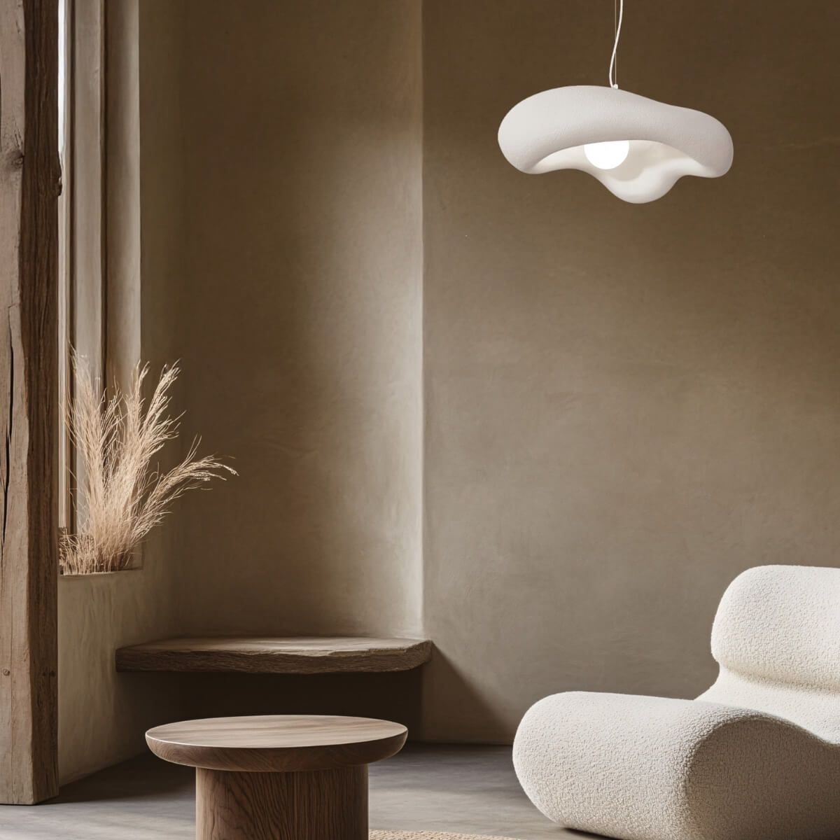 Suspension blanche design suspendue dans un salon, au-dessus d'une table et d'un fauteuil.