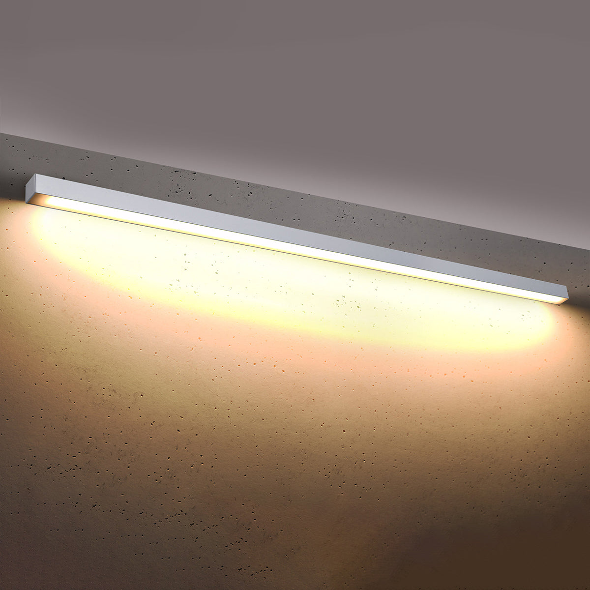 Luminaire allumé diffusant une lumière chaude sur un mur gris texturé