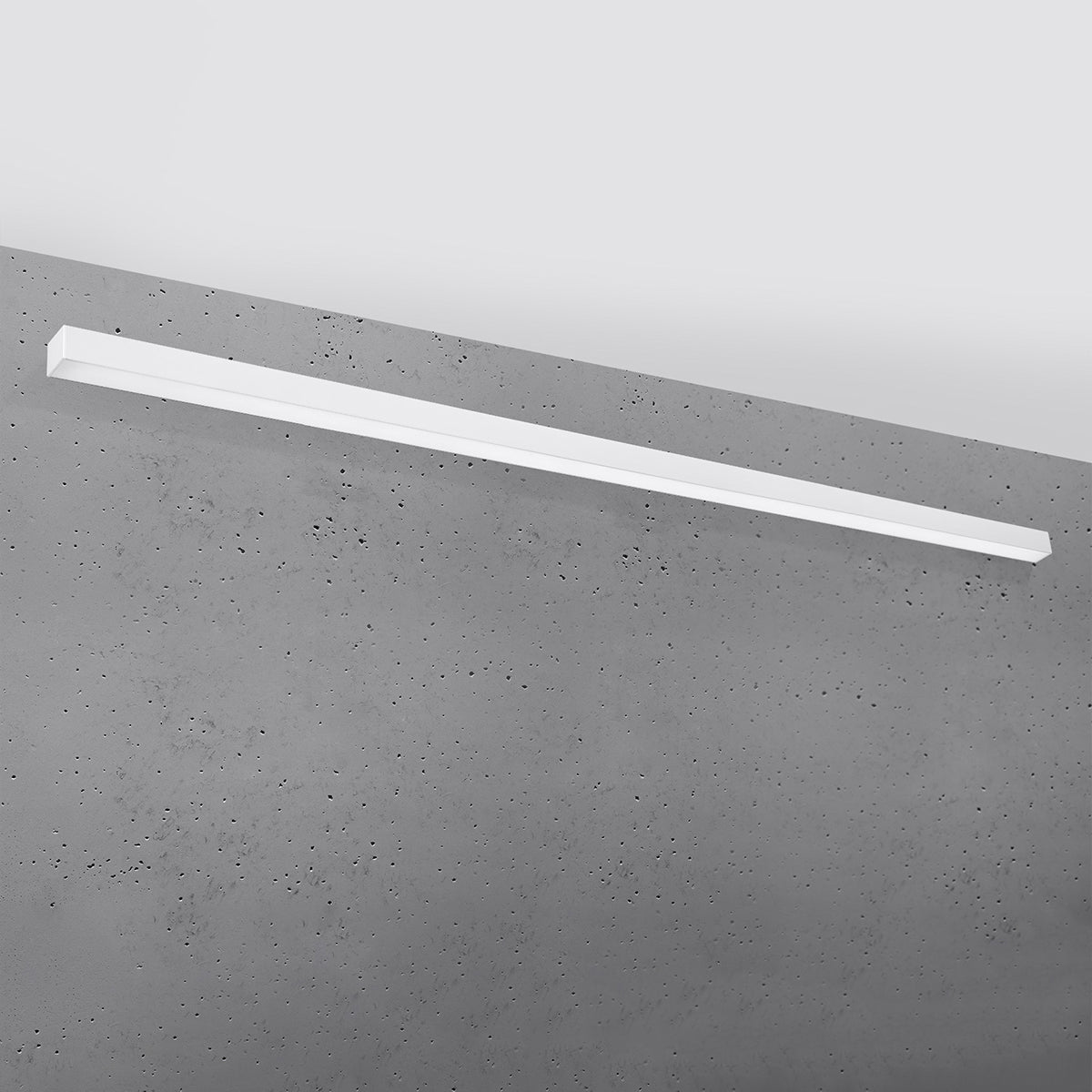 Applique blanche fixée horizontalement sur un mur en béton brut