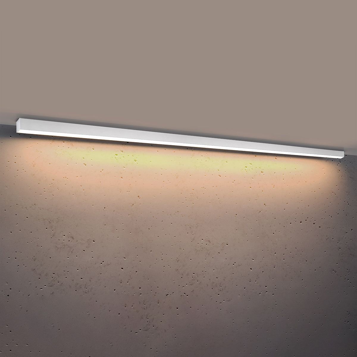 Plafonnier allumé diffusant une lumière chaude sur le mur béton texturé
