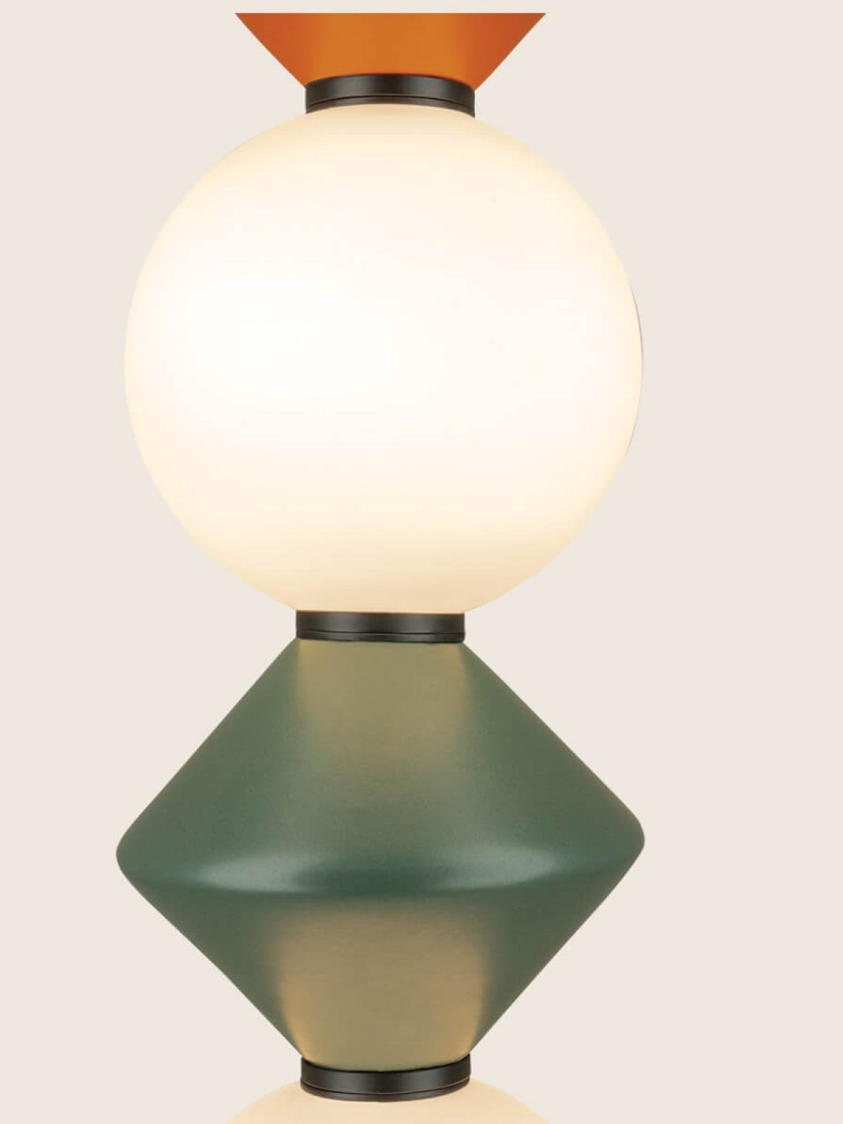 Gros plan sur l'assemblage : globe blanc, losange vert et pointe orange.