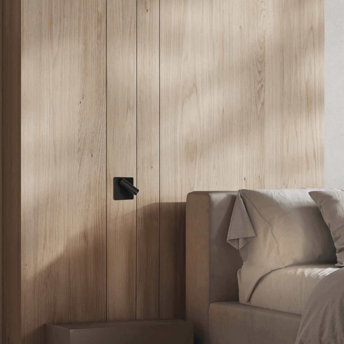 Gros plan de l'applique éteinte sur un mur lambrisé, près du lit.