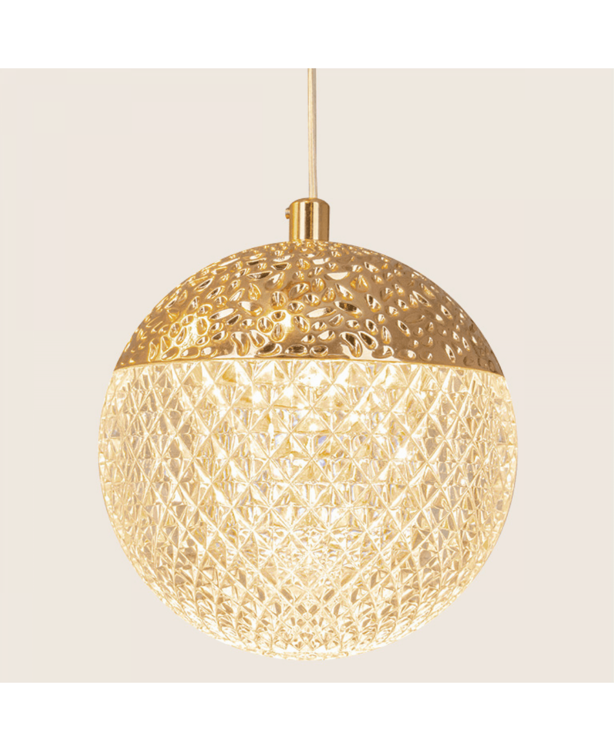 Détail de la sphère éclairée, motif ajouré doré et cristal taillé lumineux.