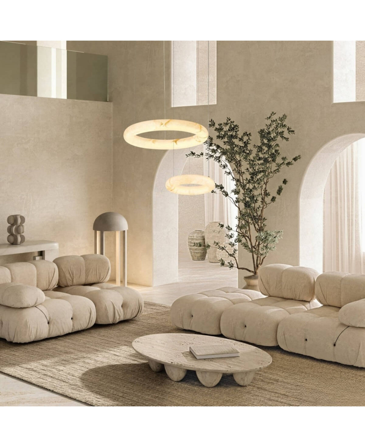 Vue large du séjour, luminaire annulaire allumé au-dessus des canapés.
