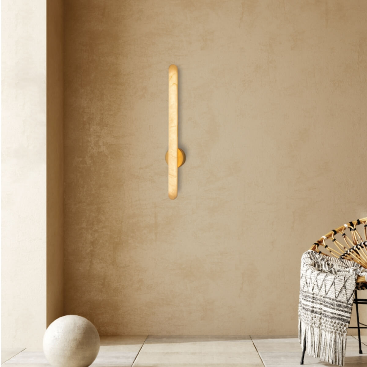 Plan large montrant l'applique lumineuse dans un intérieur beige avec fauteuil en rotin.