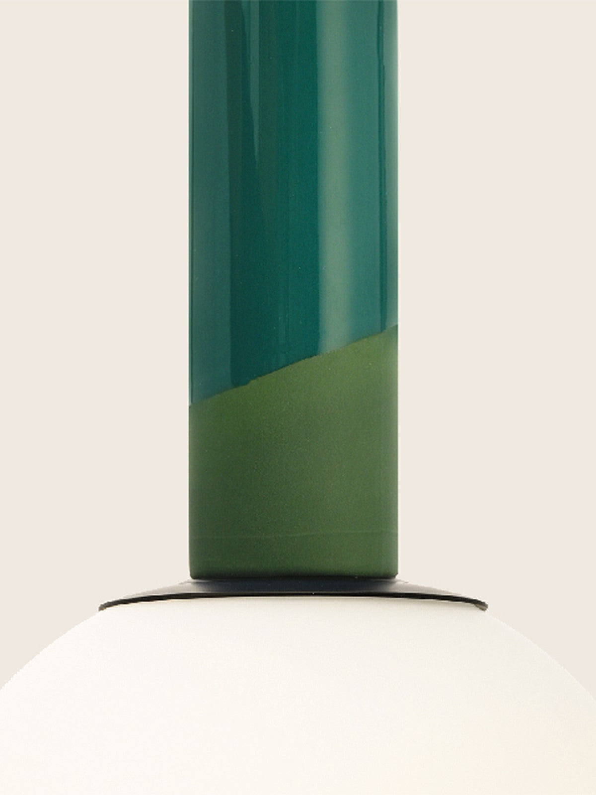 Détail de la pièce en porcelaine verte et du globe de verre opalin blanc.
