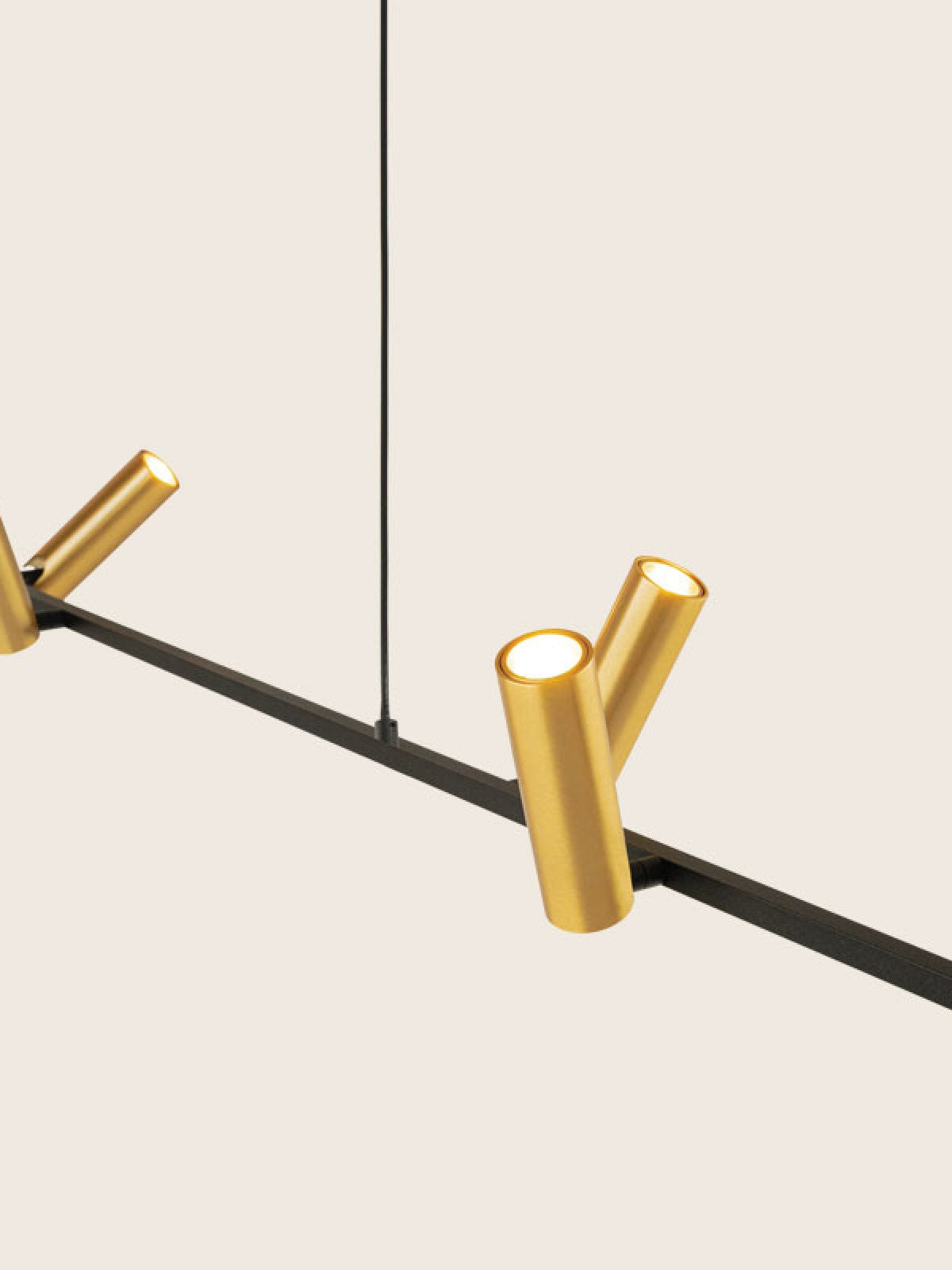 Détail rapproché des cylindres dorés orientables fixés sur le rail noir