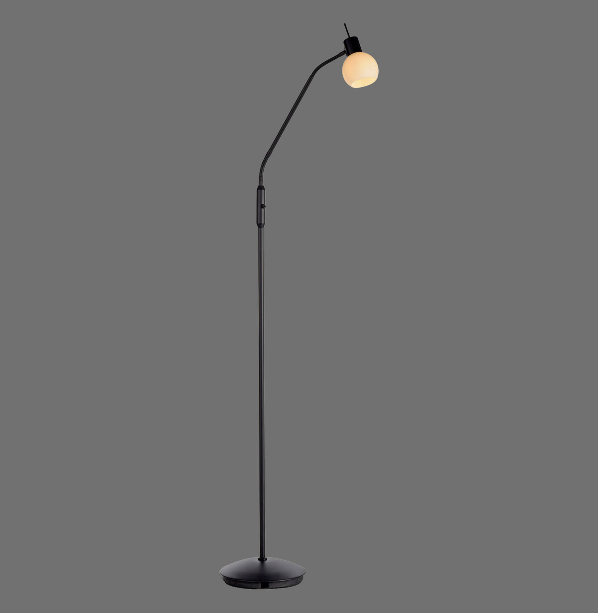 Lampadaire noir sur fond gris, pied rond et abat-jour boule en verre opalin.