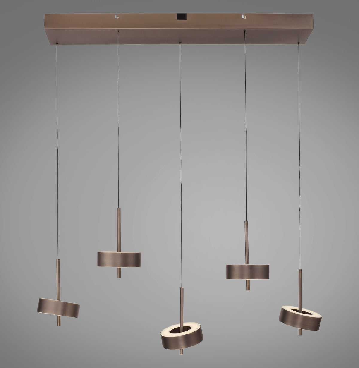 Vue de face d'une suspension à cinq spots cylindriques orientables sur fond gris neutre.