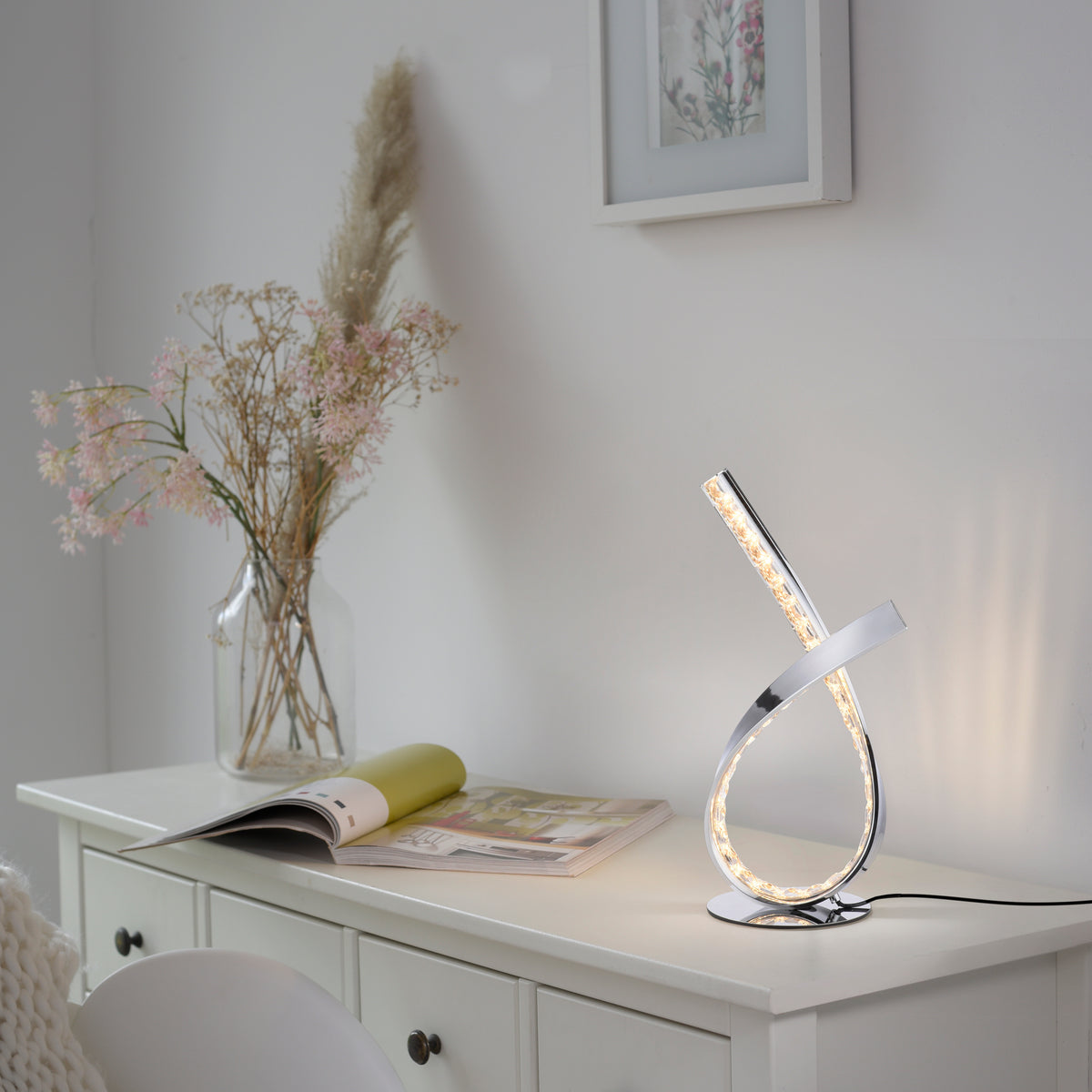 Mise en ambiance près d'un vase de fleurs séchées sur une commode blanche