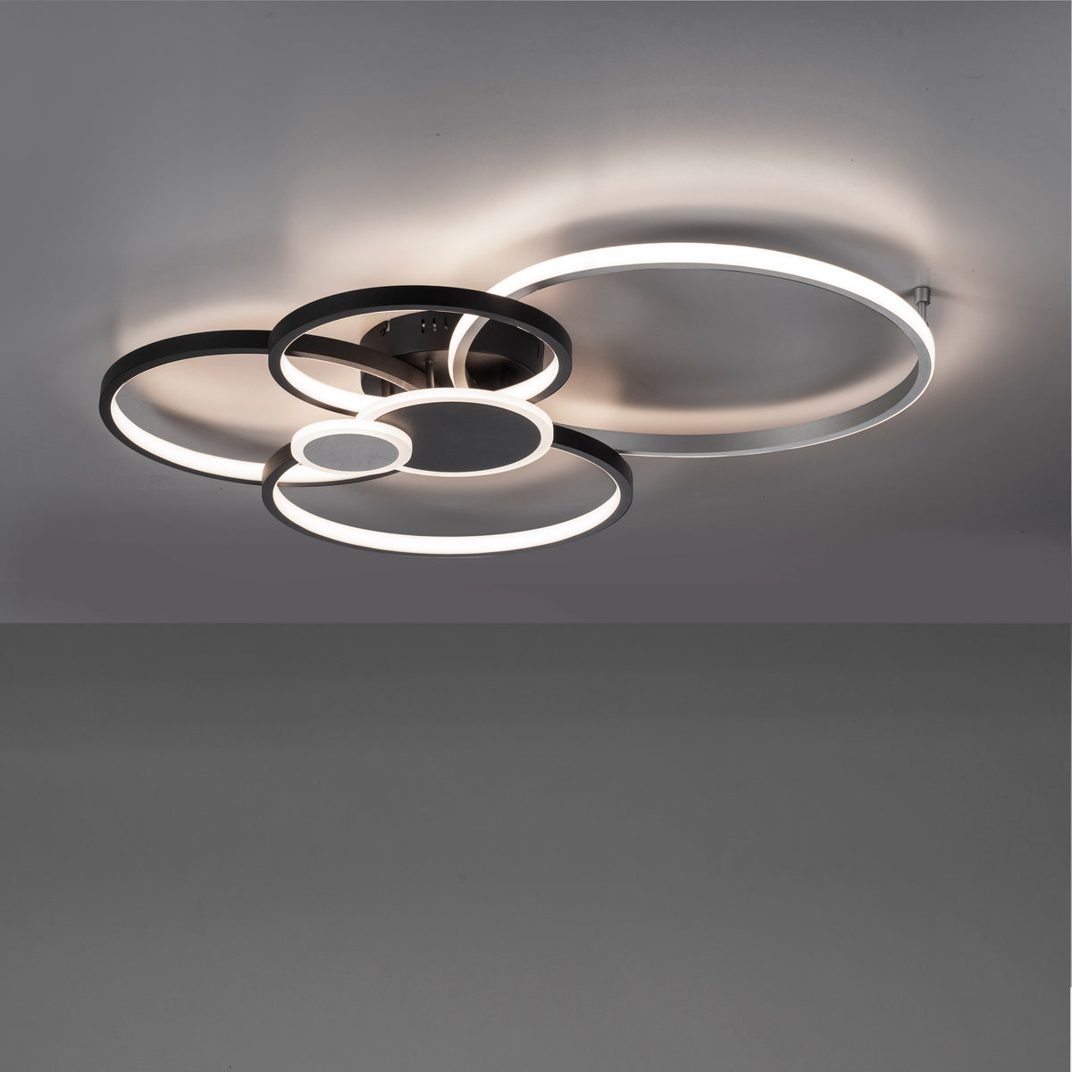 Luminaire allumé au plafond diffusant une lumière chaude dans une pièce sombre