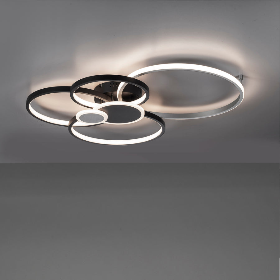 Luminaire allumé au plafond diffusant une lumière chaude dans une pièce sombre