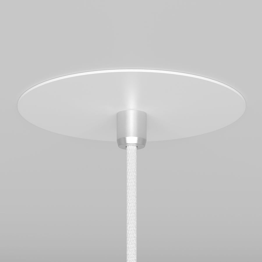 Gros plan sur la rosace blanche au plafond et le câble tressé