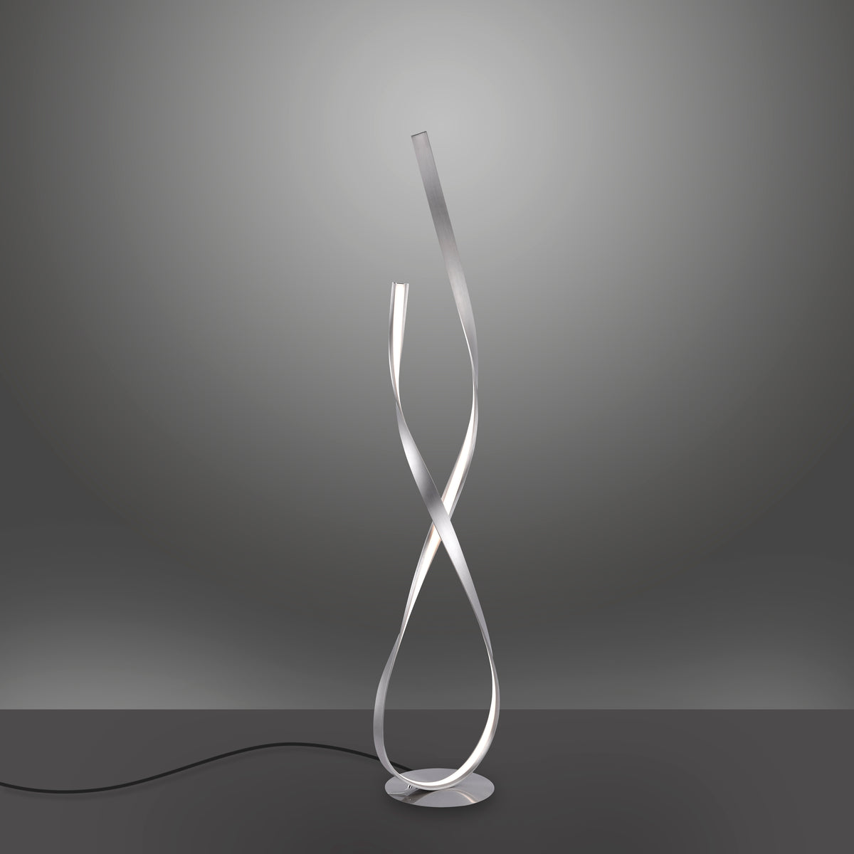 Luminaire allumé de face sur fond dégradé gris, câble d'alimentation visible au sol