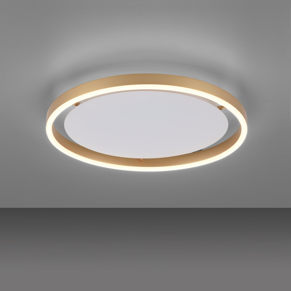 Plafonnier allumé vu de face sur fond gris foncé, halo lumineux diffus