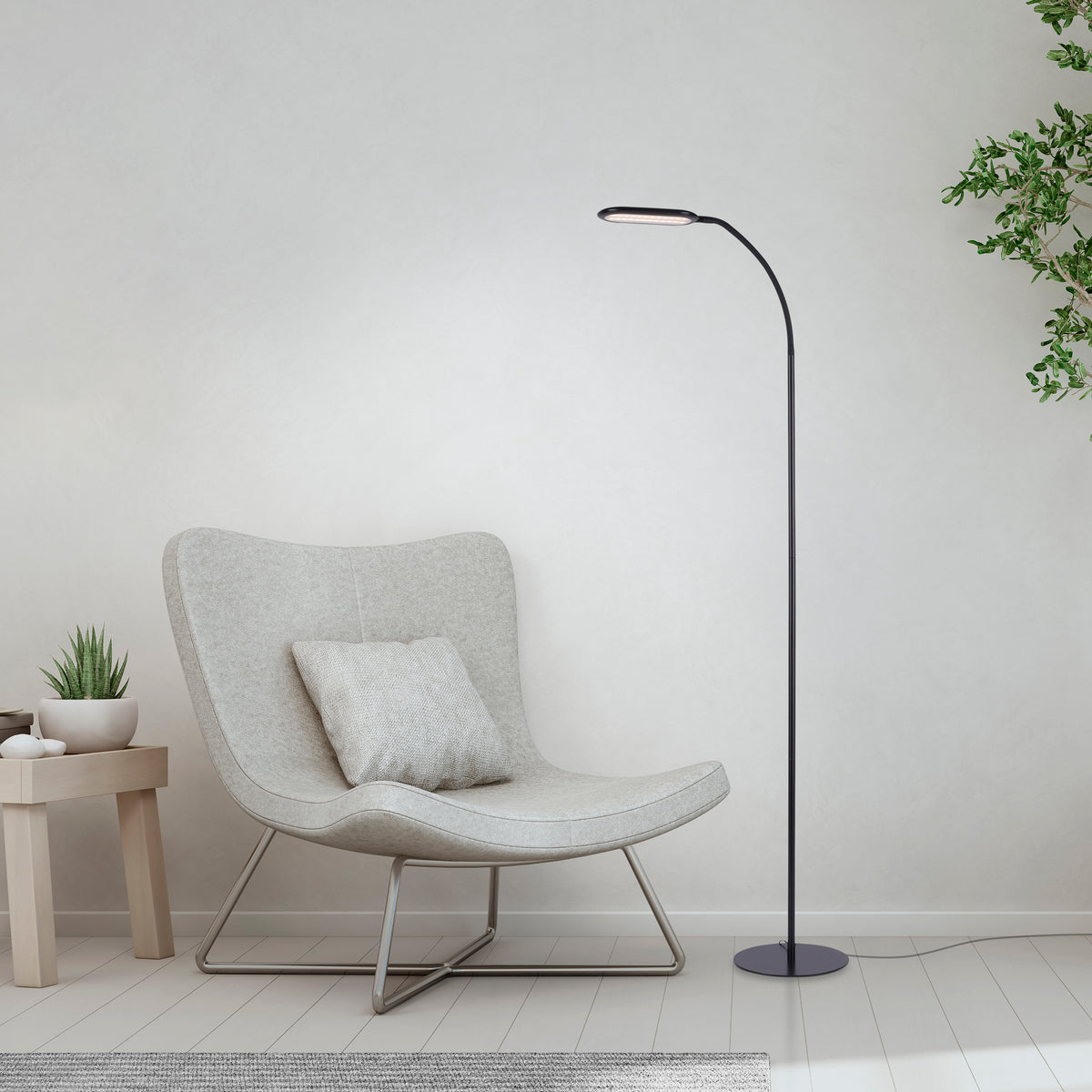 Mise en ambiance salon clair, lampadaire posé près d'un fauteuil gris et d'une petite table