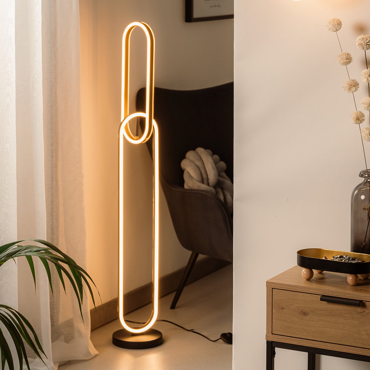 Mise en ambiance salon avec fauteuil, plante et lampadaire près du mur
