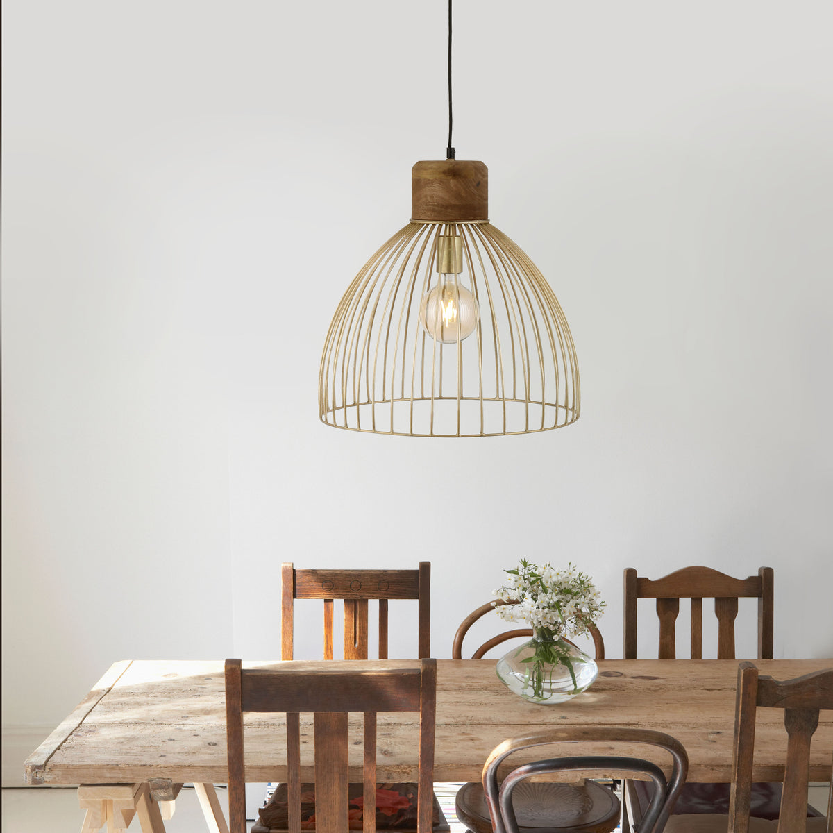 Mise en ambiance au-dessus d'une table en bois avec chaises et vase fleuri.