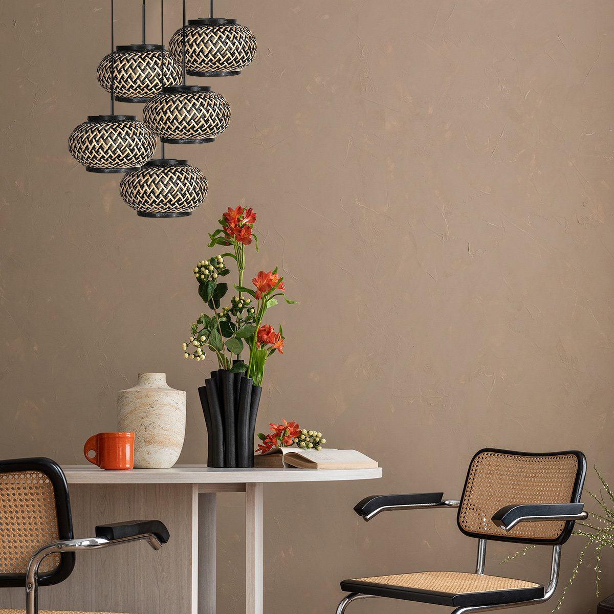 Mise en ambiance au-dessus d'une table à manger, mur beige et chaises cannées.