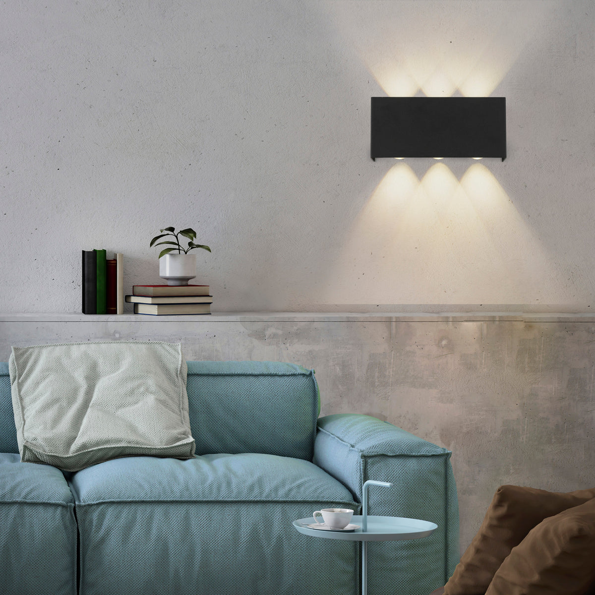 Mise en ambiance dans un salon, applique murale éclairant le mur au-dessus du canapé bleu