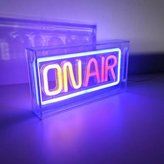 Luminaire posé sur une surface réfléchissante, éclairé et diffusant une lumière violette