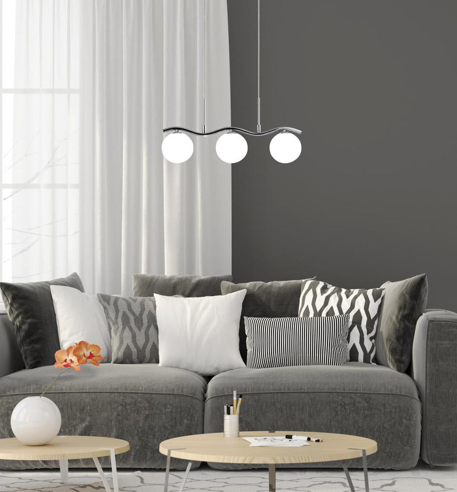 Vue rapprochée du luminaire allumé au-dessus du canapé et des tables basses claires