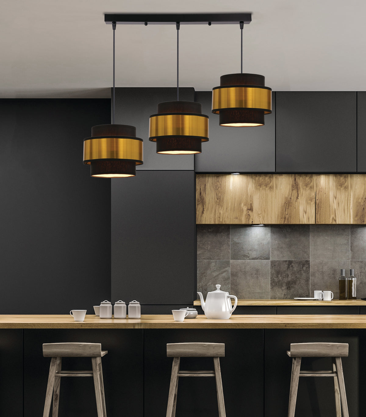Suspension allumée au-dessus d'un îlot de cuisine moderne, ambiance chaleureuse avec tabourets en bois.