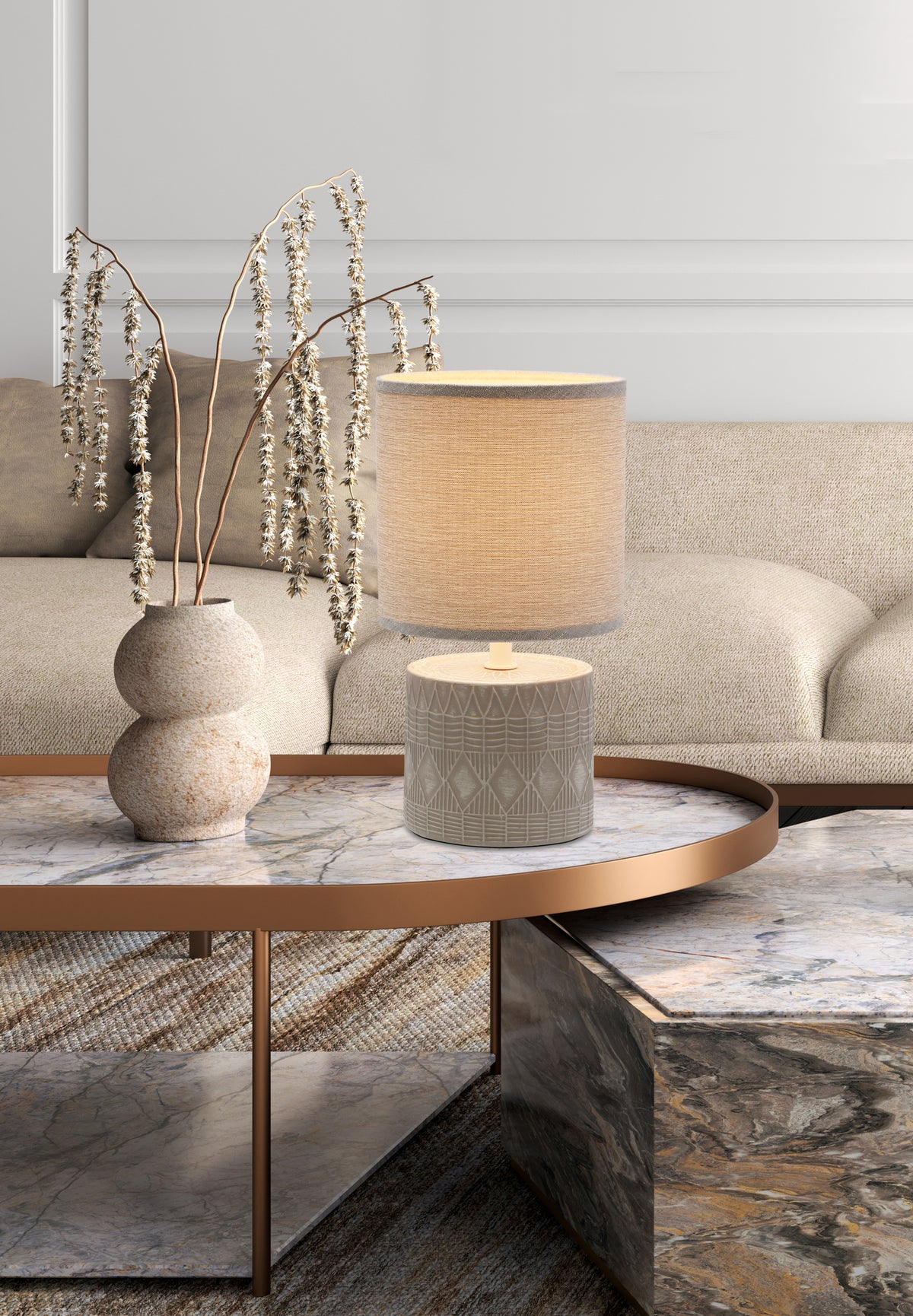 Mise en ambiance de la lampe posée sur table basse en marbre devant un canapé beige